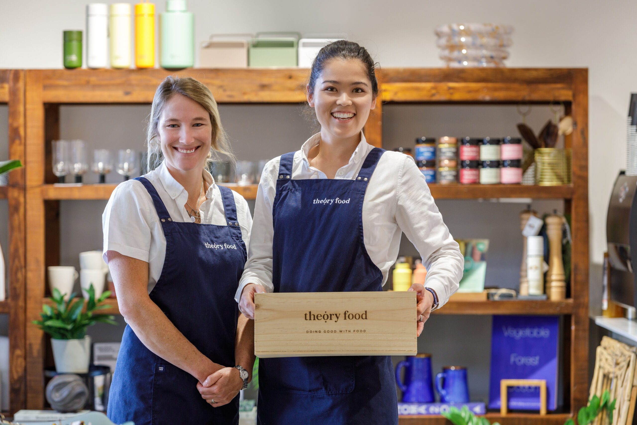 Momo Martin and Michelle Hartley of Theory Food in their New Plymouth kitchen, holding a Theory Food wooden box